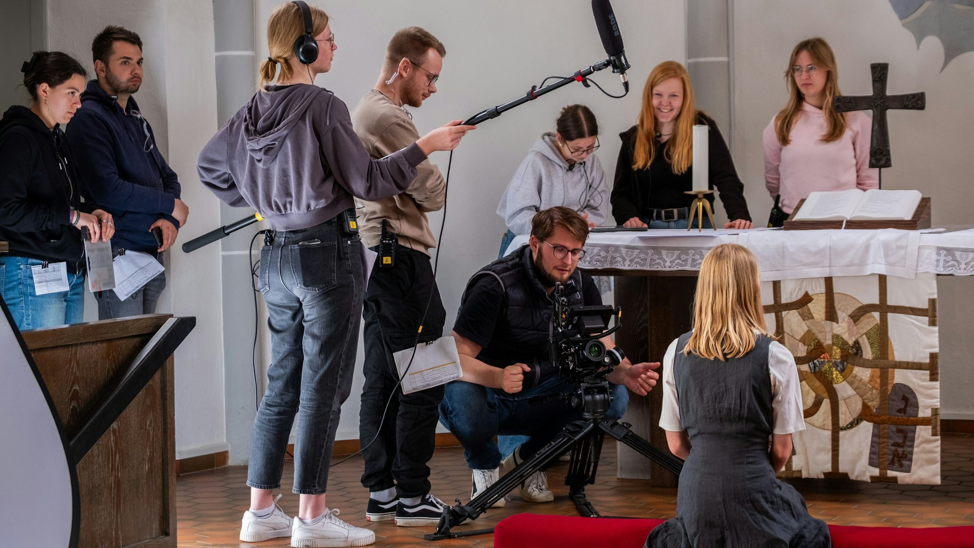 Vor dem Altar nimmt Lukas Kotthaus (hockend) gemeinsam mit seinem Team ein junges Mädchen auf.