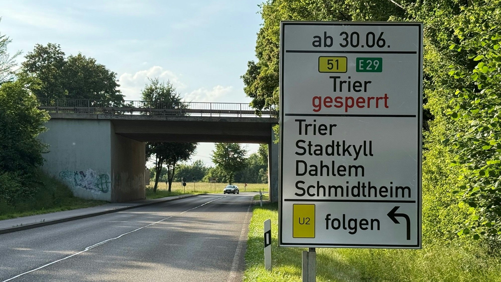 Ein Schild neben einer Straße weist darauf hin, dass die B51 gesperrt wird, und zeigt die Umleitungen an.