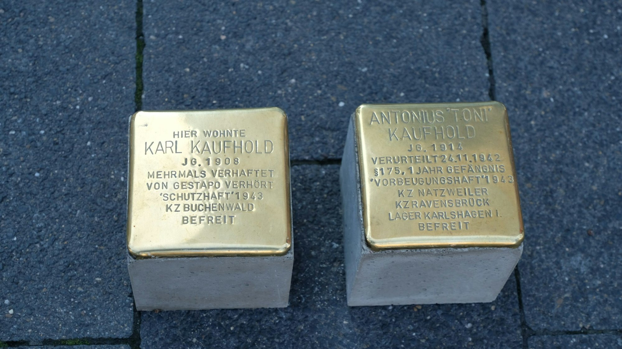 Zwei nagelneue Stolpersteine sind bereit, im Pflaster verlegt zu werden.