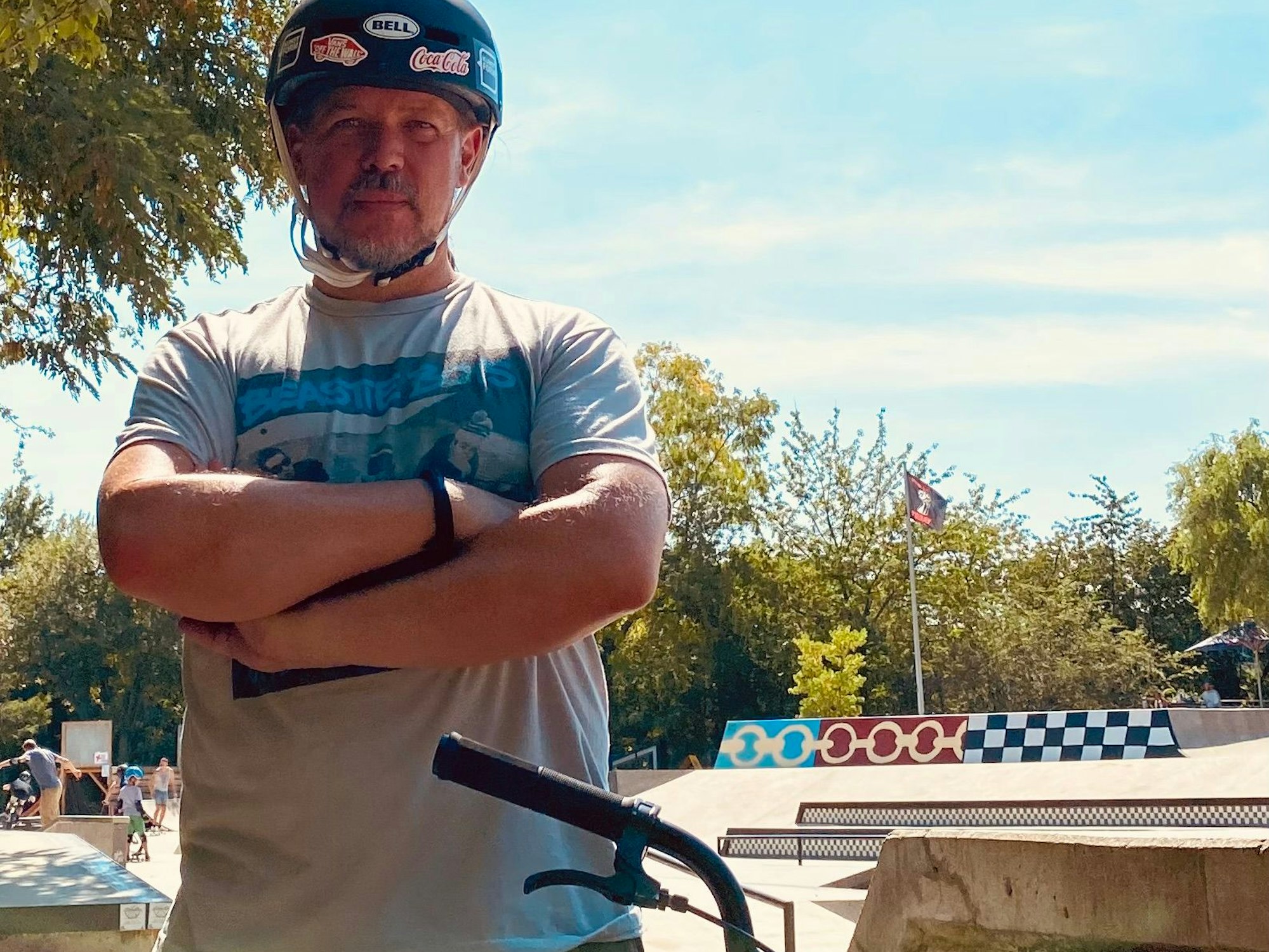 Auf dem Bild ist ein Mann mit einem BMX-Rad und einem Helm zu sehen.