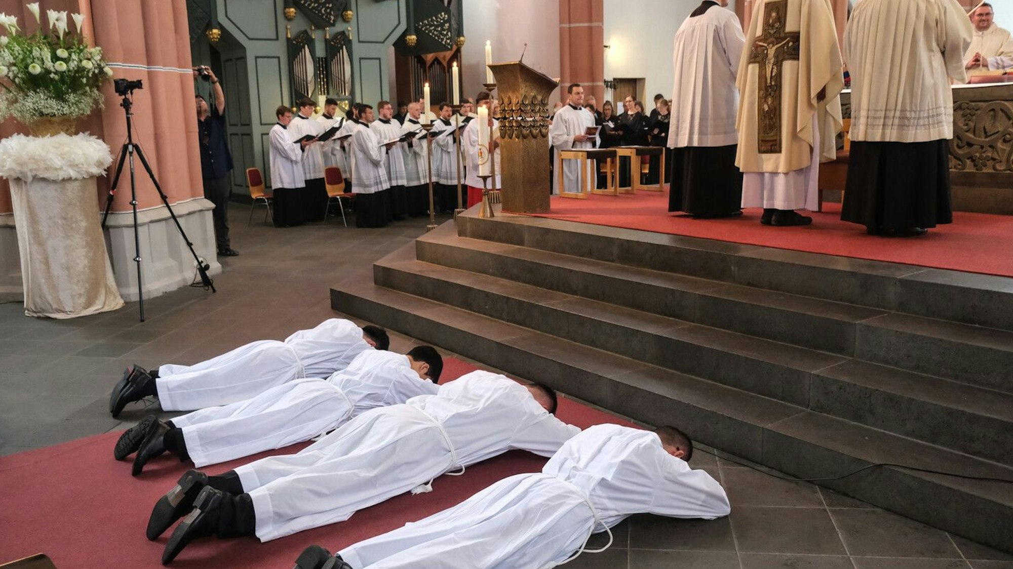Die vier Aspiranten liegen auf dem Bauch vor dem Altar.