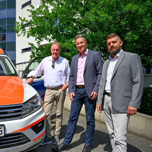 Die Kreishausmitarbeiter stehen neben einem Rettungsdienst-Fahrzeug.