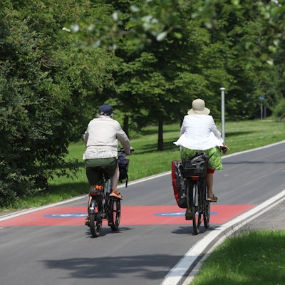 Zwei Radfahrerinnen auf einem gut ausgebauten Radweg.