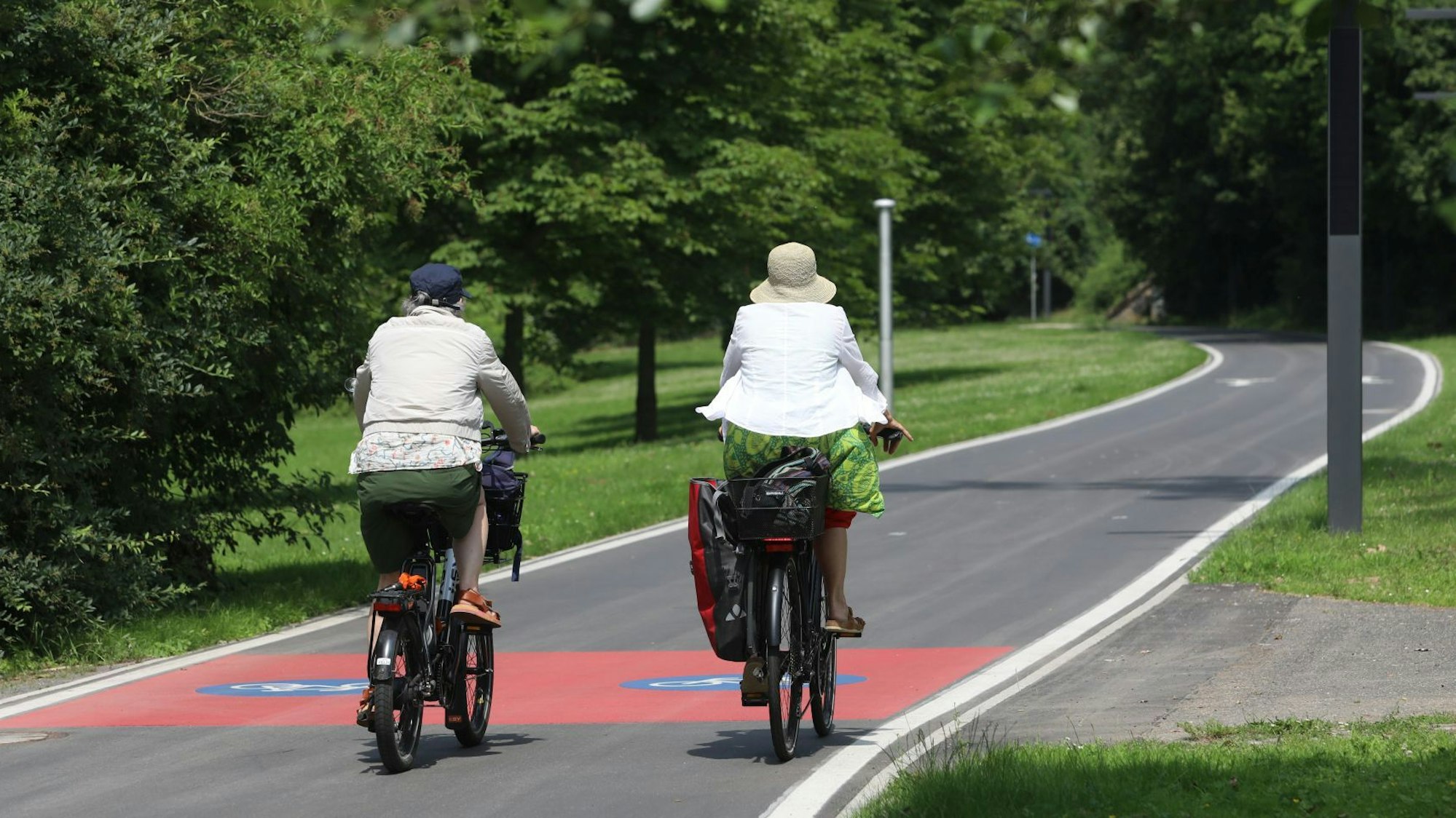 Zwei Radfahrerinnen auf einem gut ausgebauten Radweg.