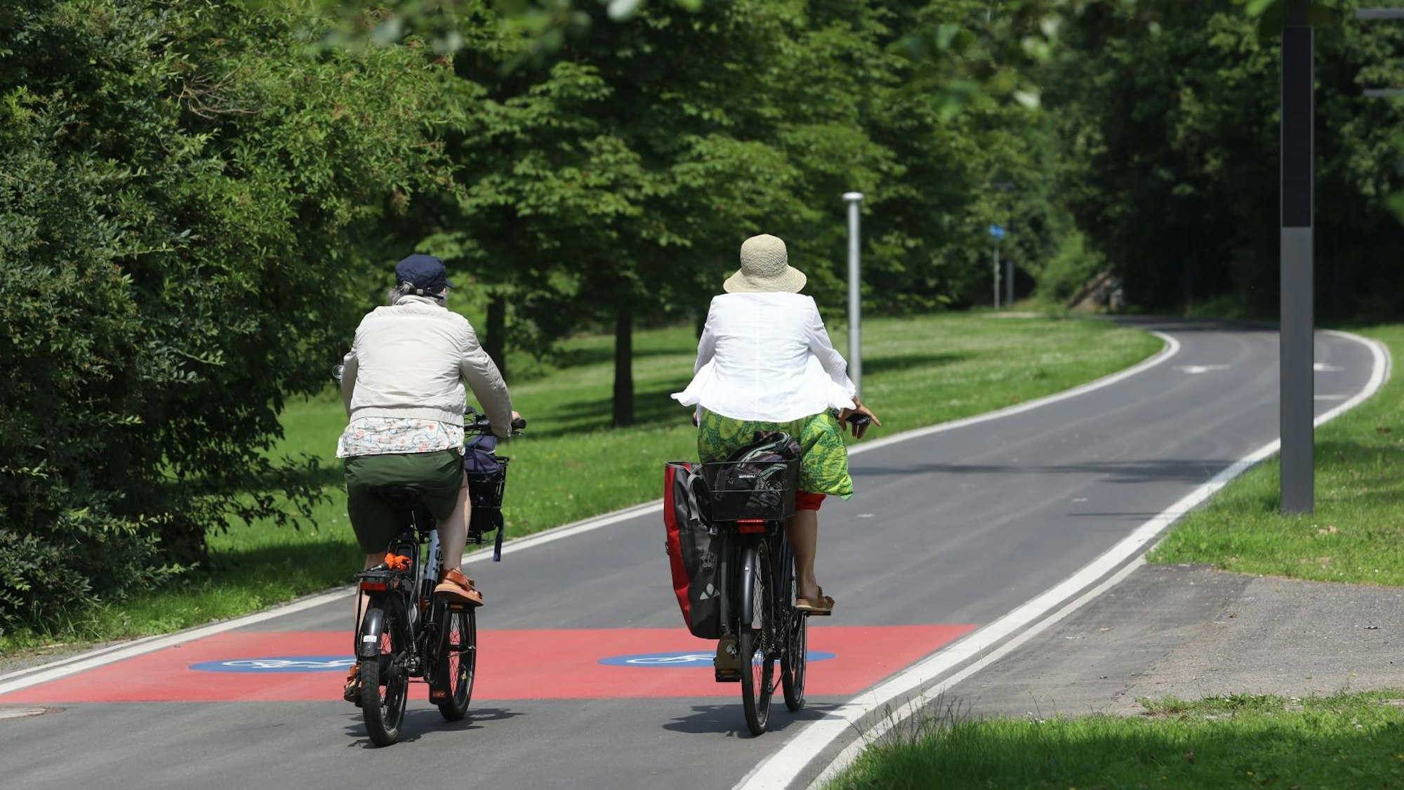Zwei Radfahrerinnen auf einem gut ausgebauten Radweg.