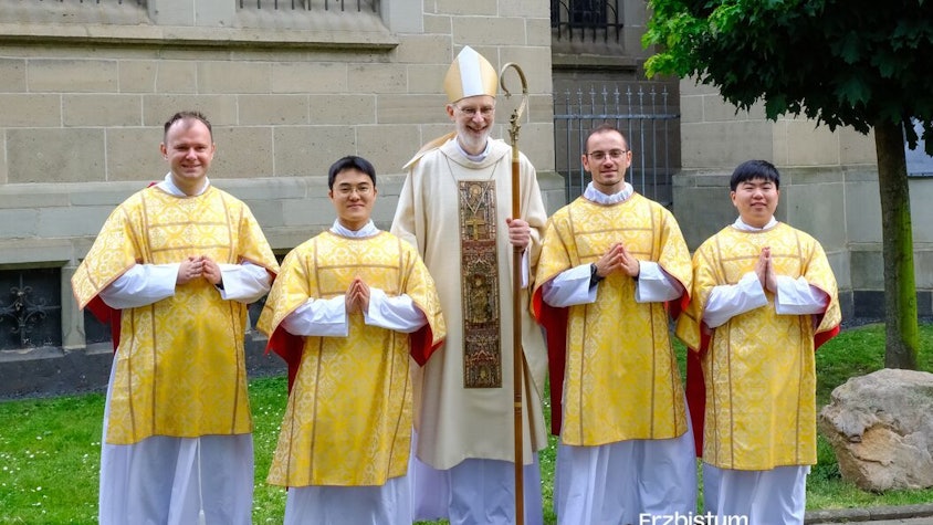 Die vier frisch geweihten Diakone haben sich mit dem Weihbischof zum Foto aufgestellt.
