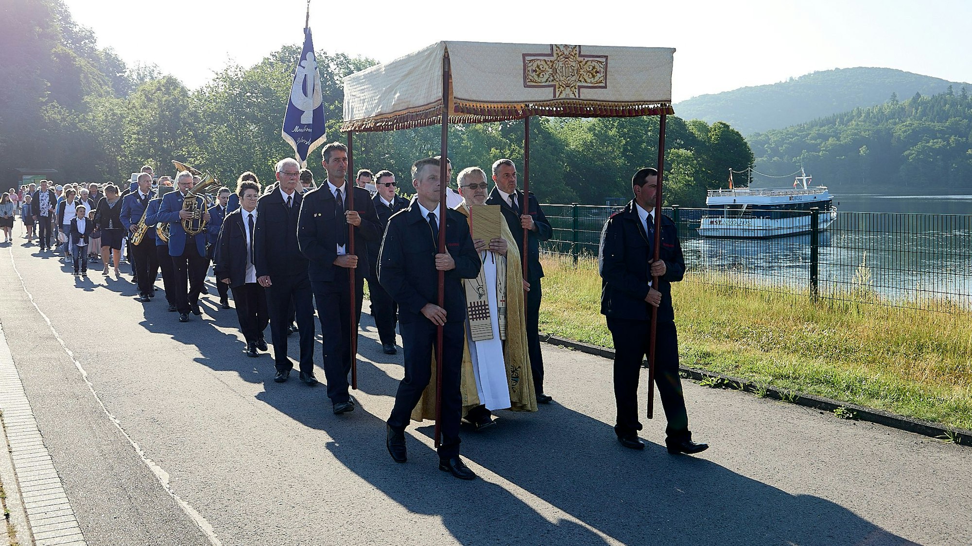 Das Bild zeigt die Prozession am Rursee. Im Hintergrund ist ein Schiff zu sehen.