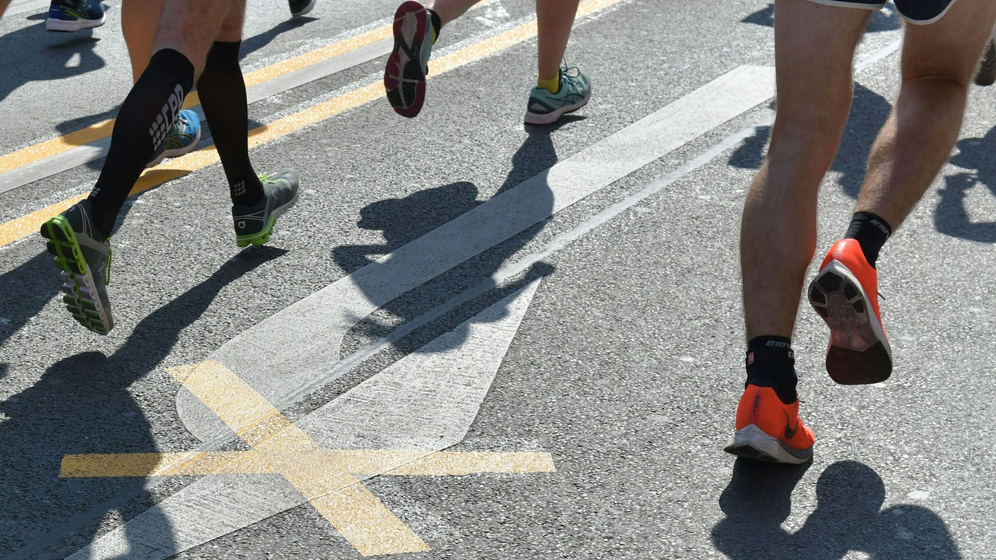 Zu sehen sind Menschen, die auf einer Straße laufen.