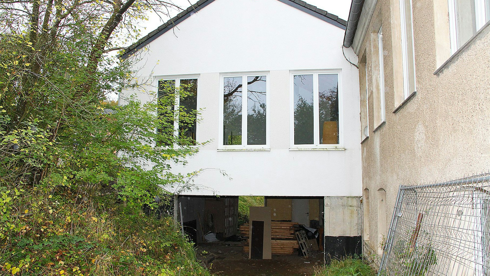 Das Bild zeigt ein Gebäude, dessen Untergeschoss nach einer Seite hin offen ist.