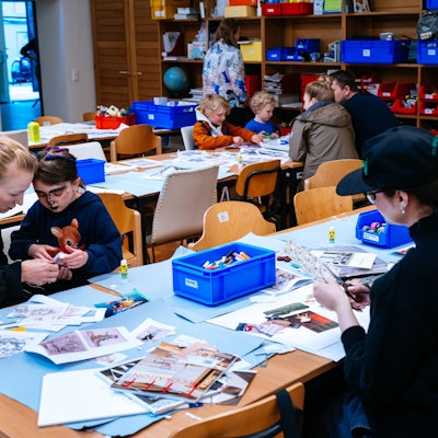 Kinder basteln mit Papier und Schere.