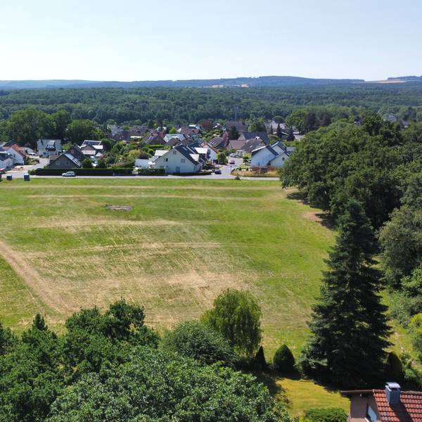 Die Drohnenaufnahme zeigt das geplante Baugebiet Am Rothenloch, das am Ortsrand von Satzvey (im Hintergrund) in Richtung Firmenich entstehen soll.