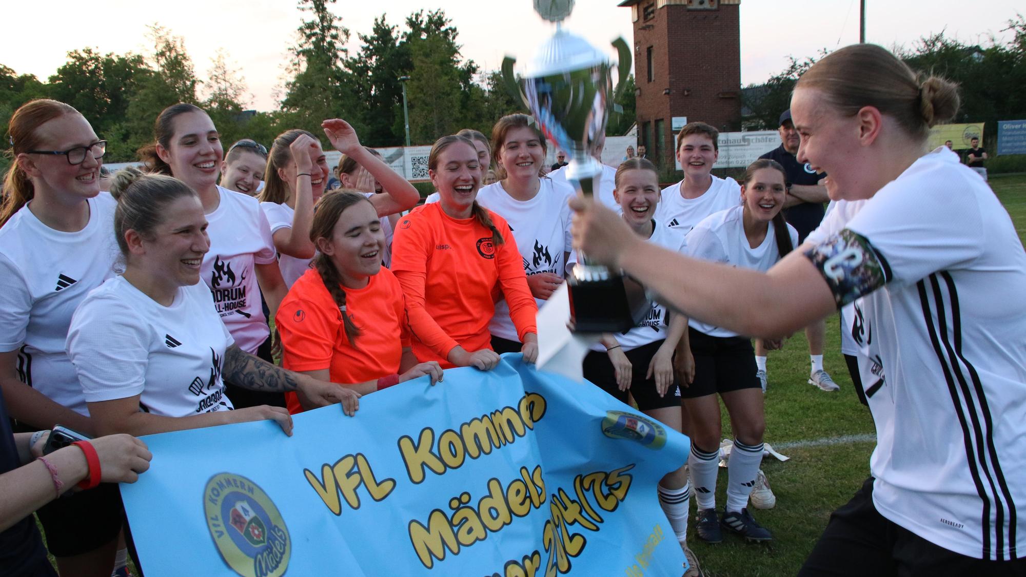 Fussball Kreispokalfinale der Frauen VfL Kommern - SG Erfthoehen 98: Nele Wagner (r.) mit der Pokal in der Hand unter Jubel ihrer Mitspielerinnen.