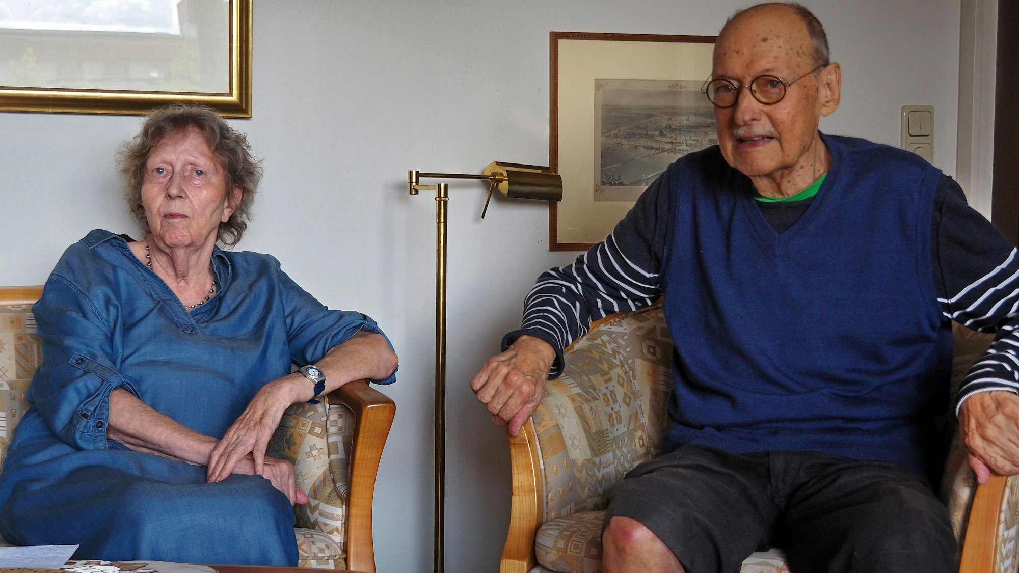 Eine ältere Frau und ein älterer Mann sitzen nebeneinander.