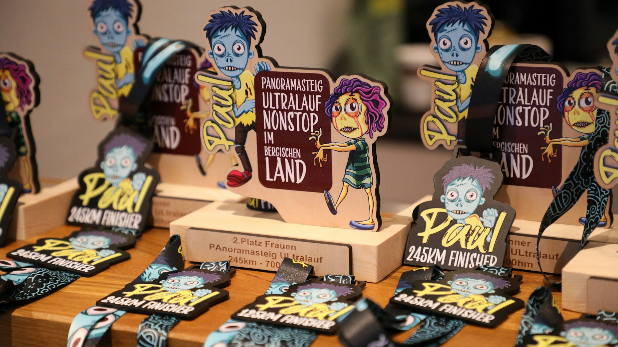 Trophäen und Medaillen für die Siegerinnen und Sieger des Panoramasteig-Ultralaufs stehen beziehungsweise liegen auf der Theke im Dorfgemeinschaftshaus in Lindlar-Remshagen..
