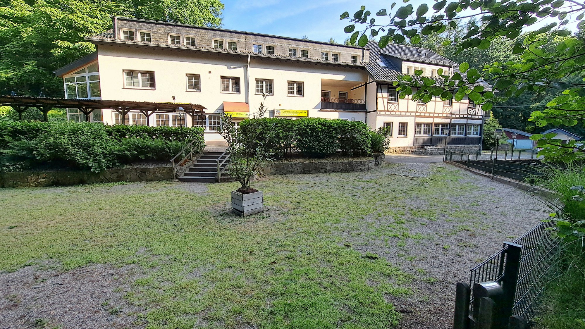 Zwischen Teich und Forsbacher Mühle ist ein leerer geschotterter Platz zu sehen.