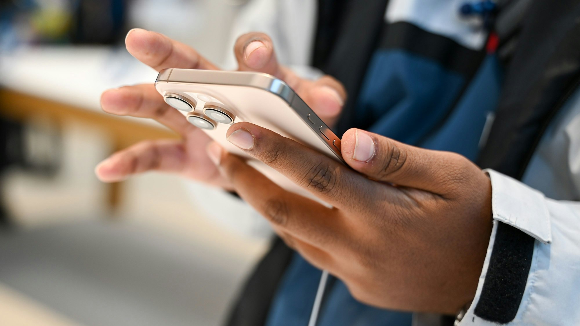 Ein Mann schaut sich sein neues iPhone 16 an.