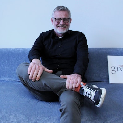 Ein Mann sitzt auf einem blauen Sofa.