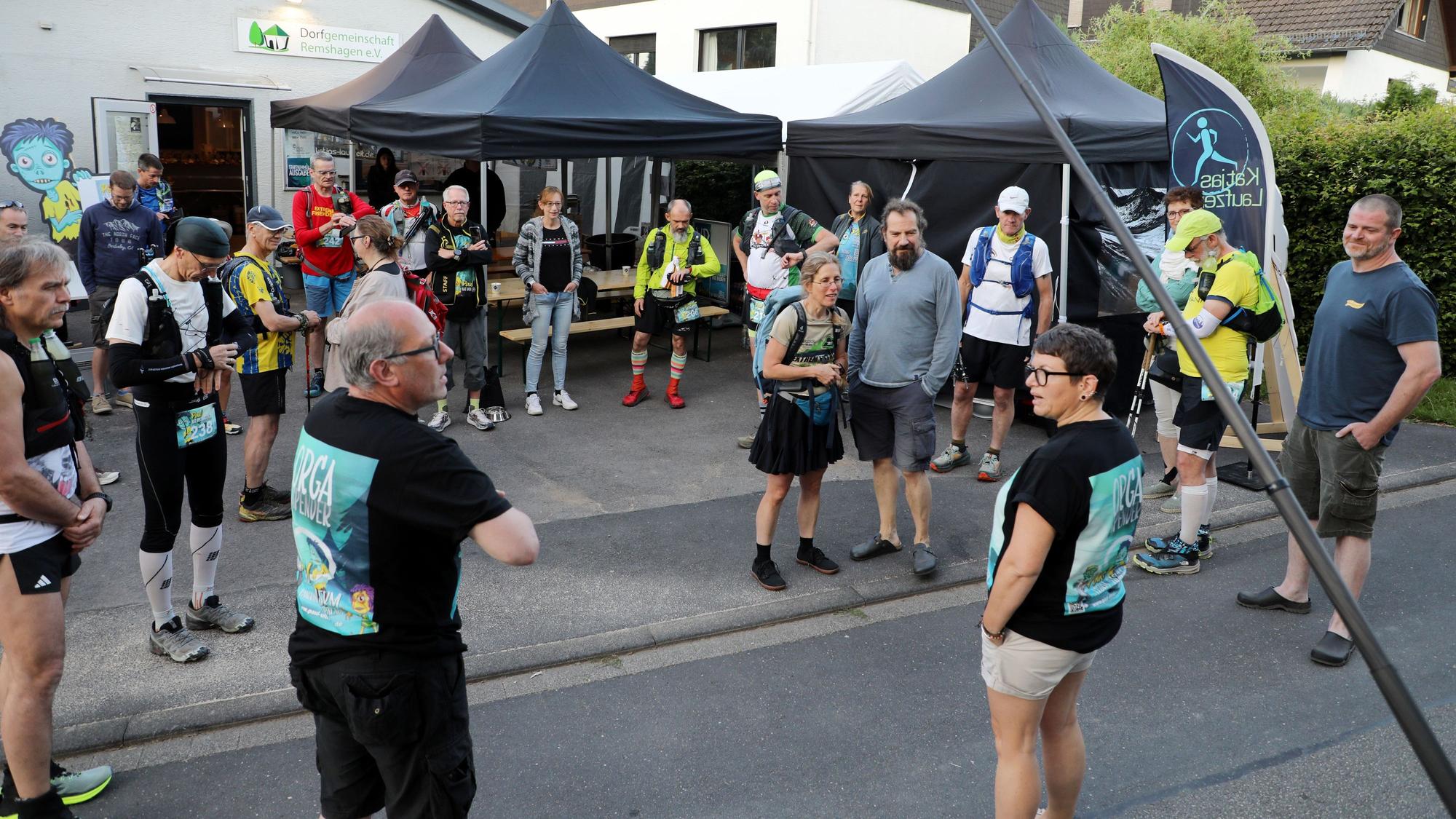 Die Organisatoren Thorsten Klenke aus Lindlar und Katja Dasbach aus Stebach bei Montabaur begrüßen die erste Startergruppe zum Panoramasteig-Ultralauf vor dem Dorfgemeinschaftshaus in Lindlar-Remshagen.