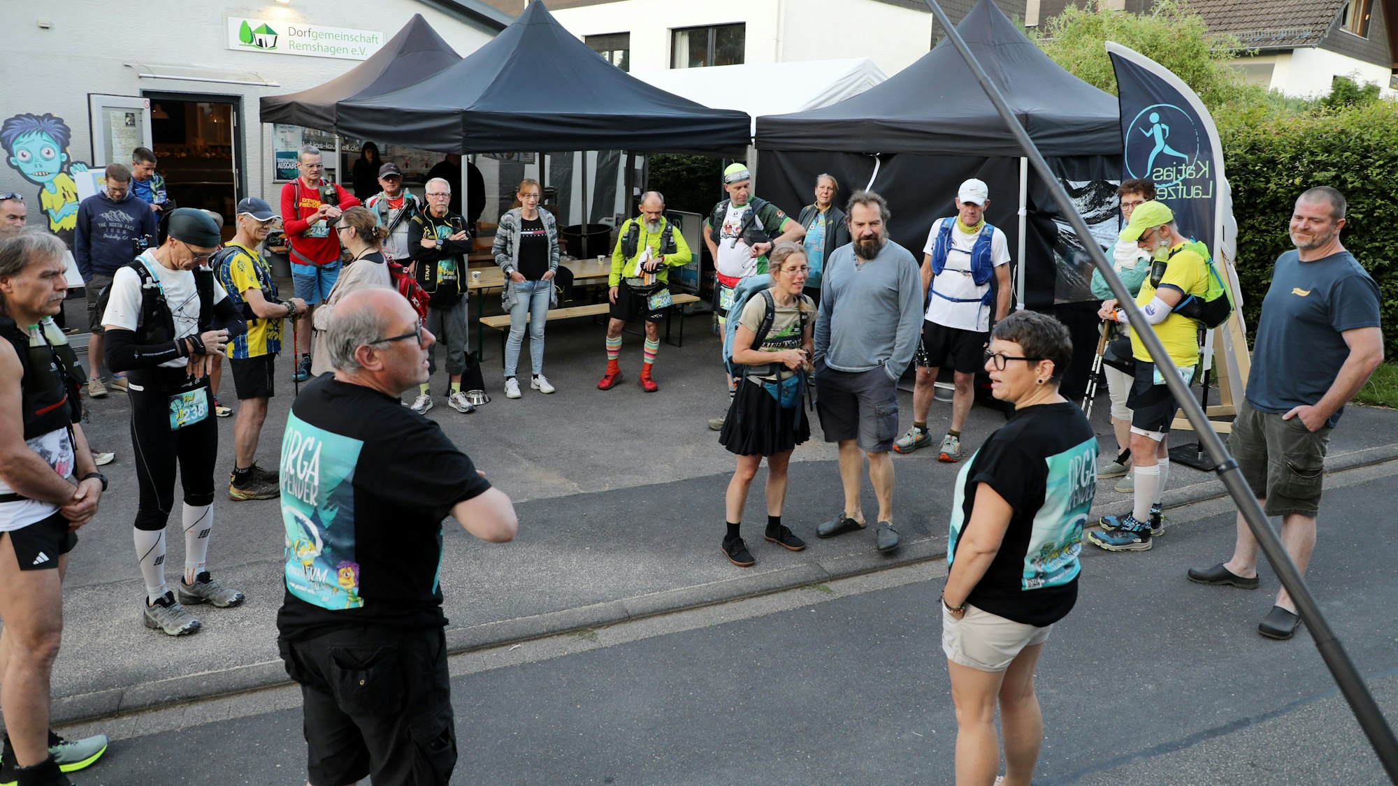 Die Organisatoren Thorsten Klenke aus Lindlar und Katja Dasbach aus Stebach bei Montabaur begrüßen die erste Startergruppe zum Panoramasteig-Ultralauf vor dem Dorfgemeinschaftshaus in Lindlar-Remshagen.