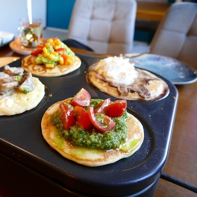 Vier Pancakes liegen auf einer mobilen Garplatte, belegt mit süßen und herzhaften Zutaten.