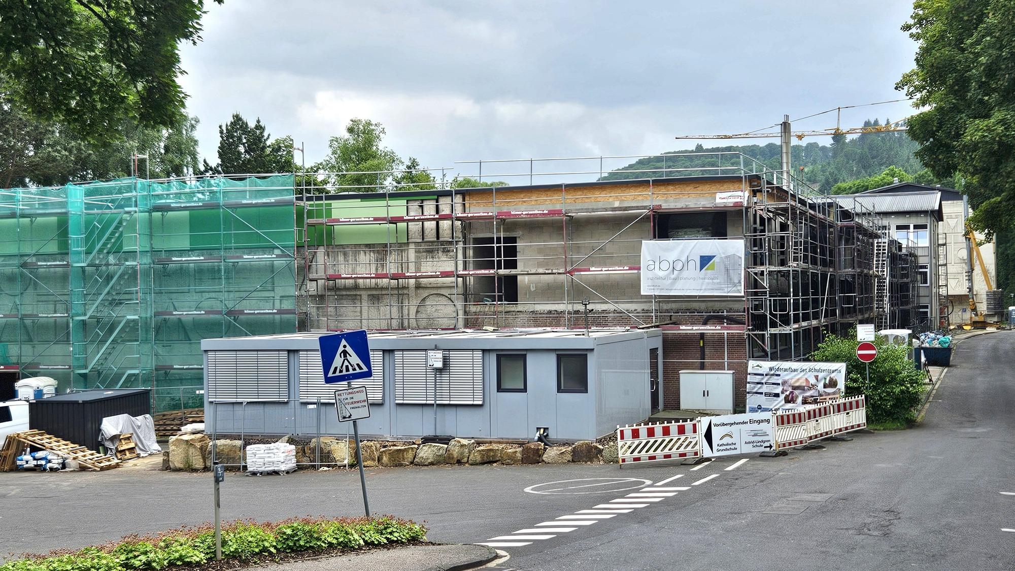 Blick auf die eingerüstete Turnhalle. Im Hintergrund ist ein Kran zu sehen.