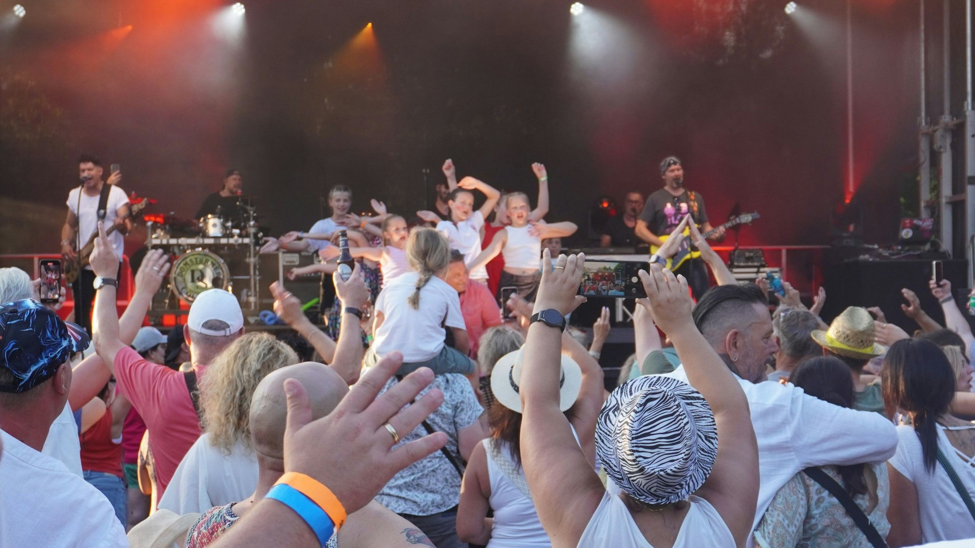 Auf dem Bild ist ein jubelndes Publikum vor einer Bühne zu sehen.