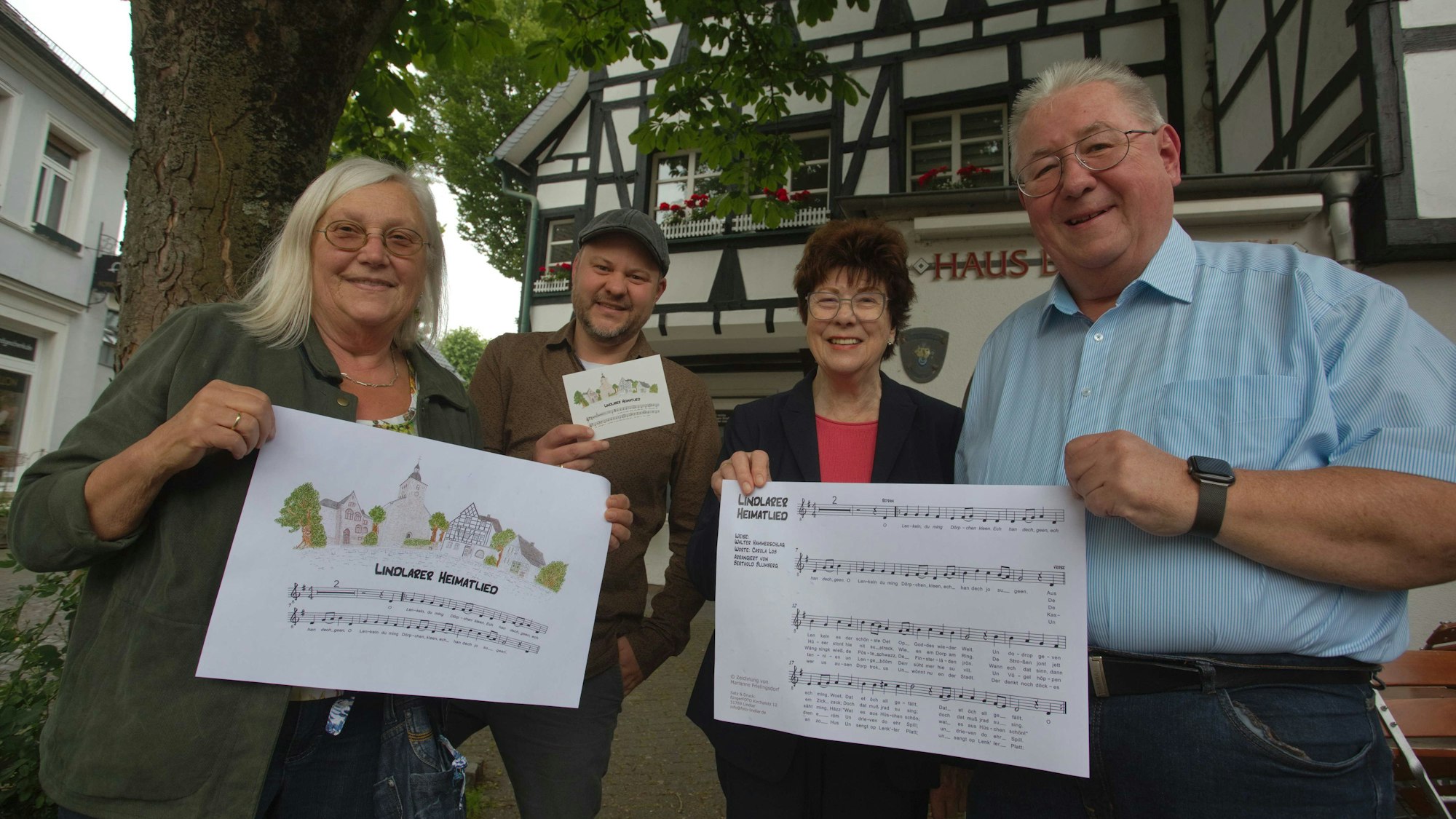 Das Foto zeigt Marianne Frielingsdorf, Thilo Fünger, Rosalinde Wiemann und Berthold Blumberg mit dem Text und den Noten des Lindlarer Heimatliedes.