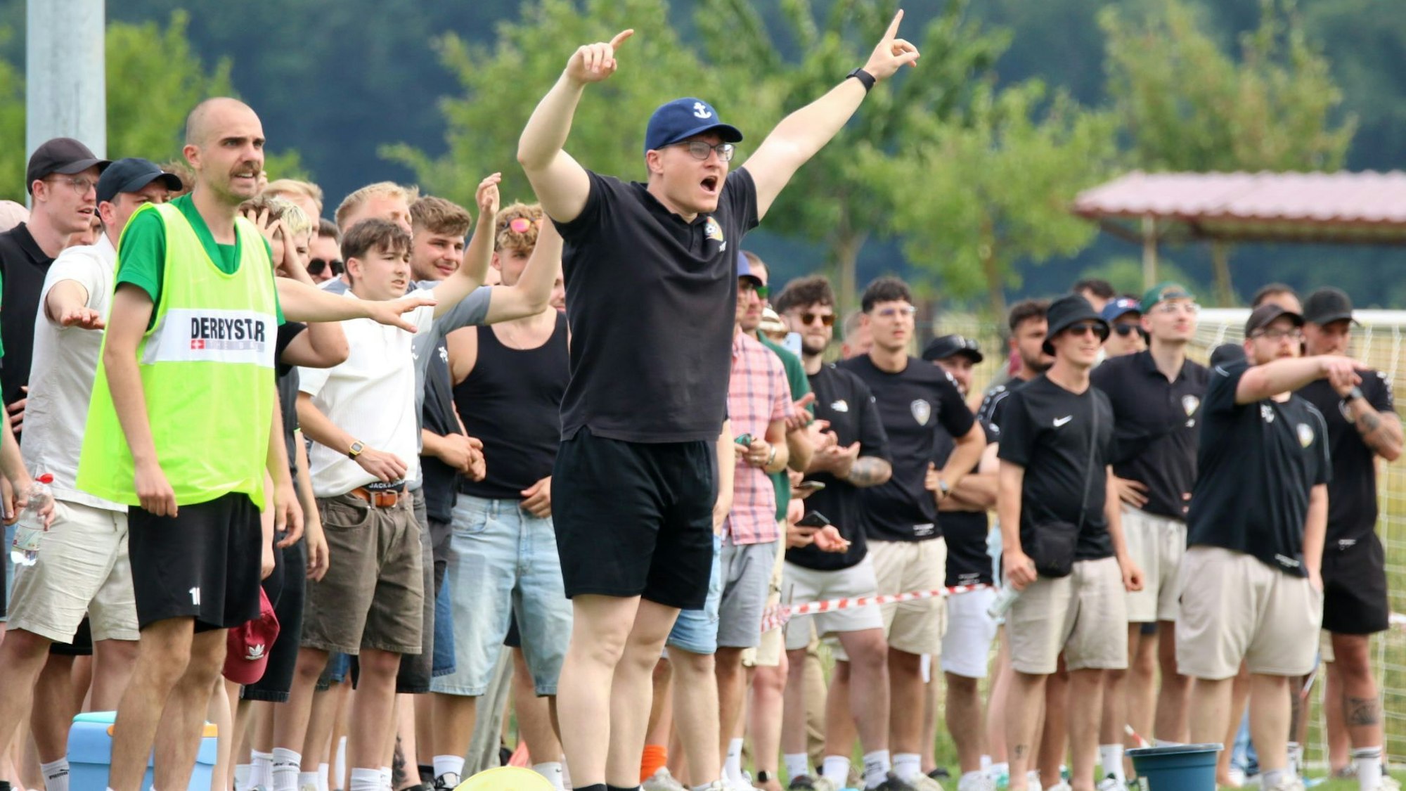 FlaKi-Trainer Marco Markwald gestikuliert am Spielfeldrand. Hinter ihm die Fans und Auswechselspieler.