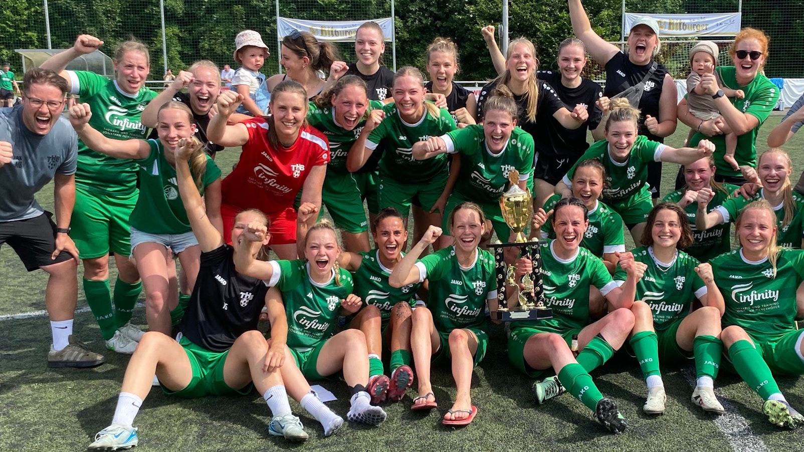 Die Fußballerinnen und das Trainerteam jubeln mit dem Pokal .