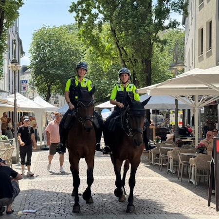 Zu sehen sind zwei Reiterinnen der Polizei auf ihre Pferden in der Brühler Fußgängerzone.