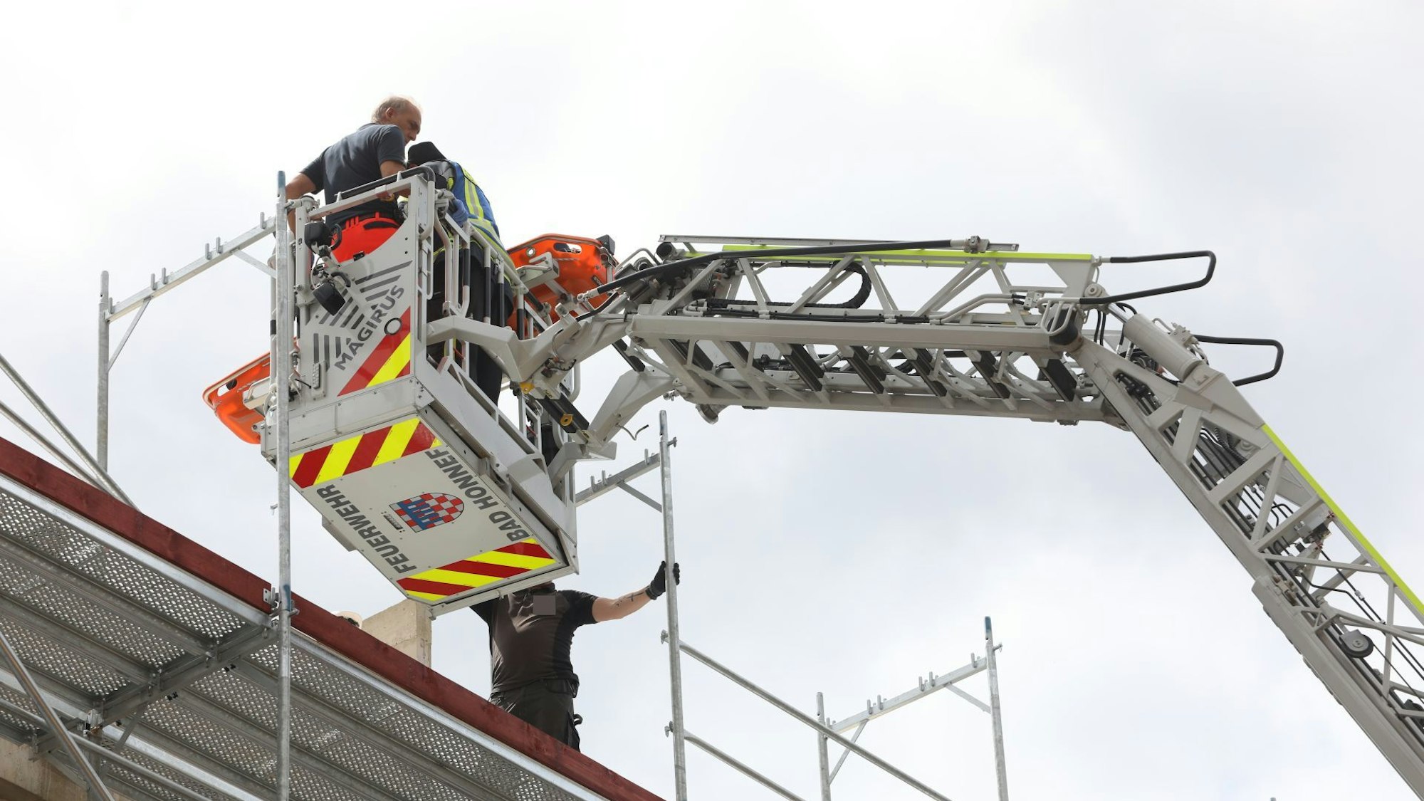 Der Korb der Drehleiter der Feuerwehr Bad Honnef am Obergeschoss einer Baustelle.