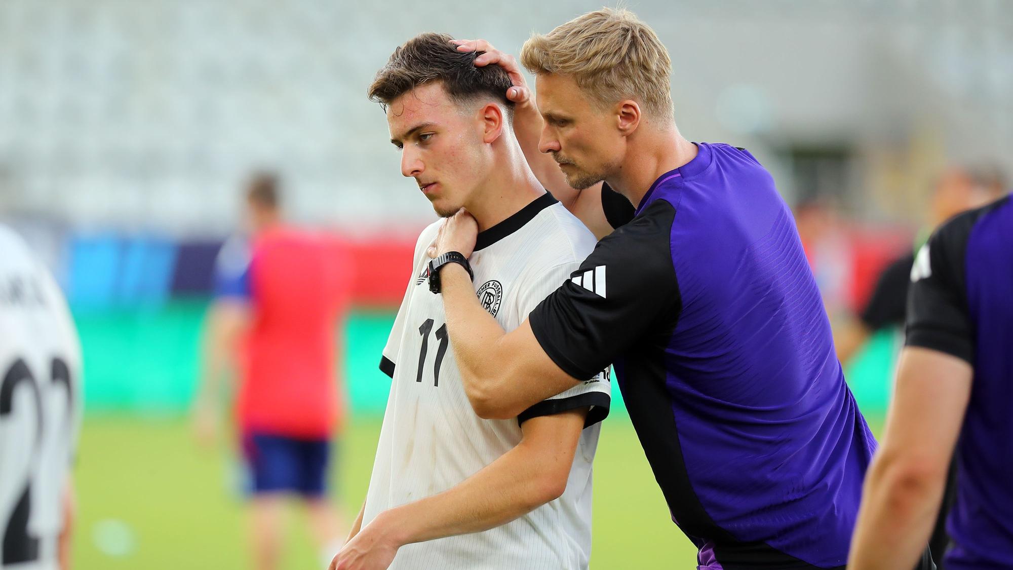 Bukarest: Fußball, U19 Männer: EM, Spanien - Deutschland, Finalrunde, Halbfinale, ein Mitglied des Trainerstabs tröstet ##Said El Mala von Deutschland nach dem Spiel.