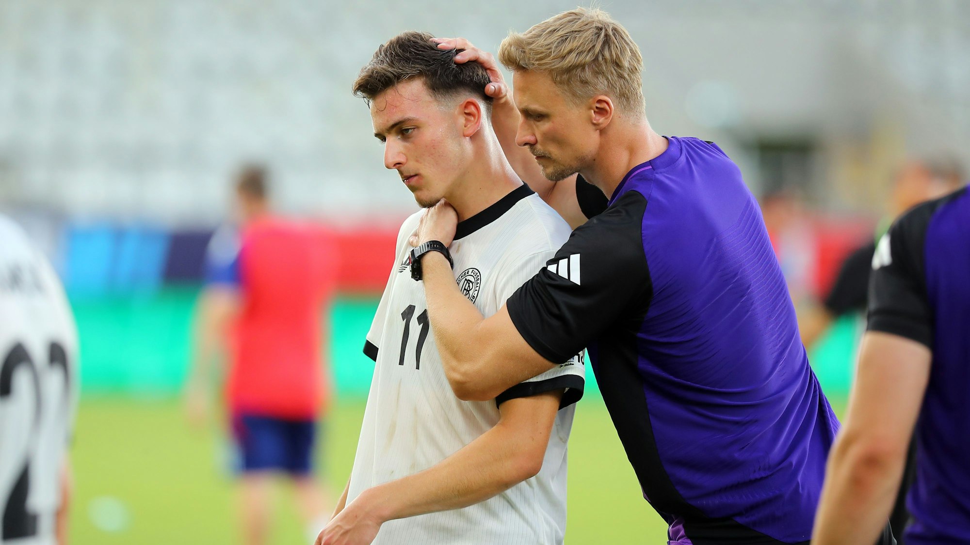 Bukarest: Fußball, U19 Männer: EM, Spanien - Deutschland, Finalrunde, Halbfinale, ein Mitglied des Trainerstabs tröstet ##Said El Mala von Deutschland nach dem Spiel.