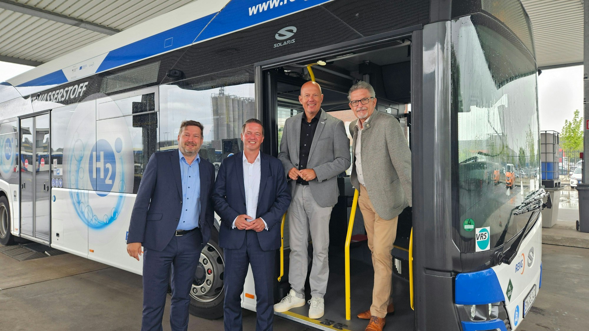 Zu sehen sind REVG-Geschäftsführer Martin Gawrisch, Aufsichtsratsvorsitzender Gregor Golland, Landrat Frank Rock und Geschäftsführer Walter Reinarz vor einem Bus.