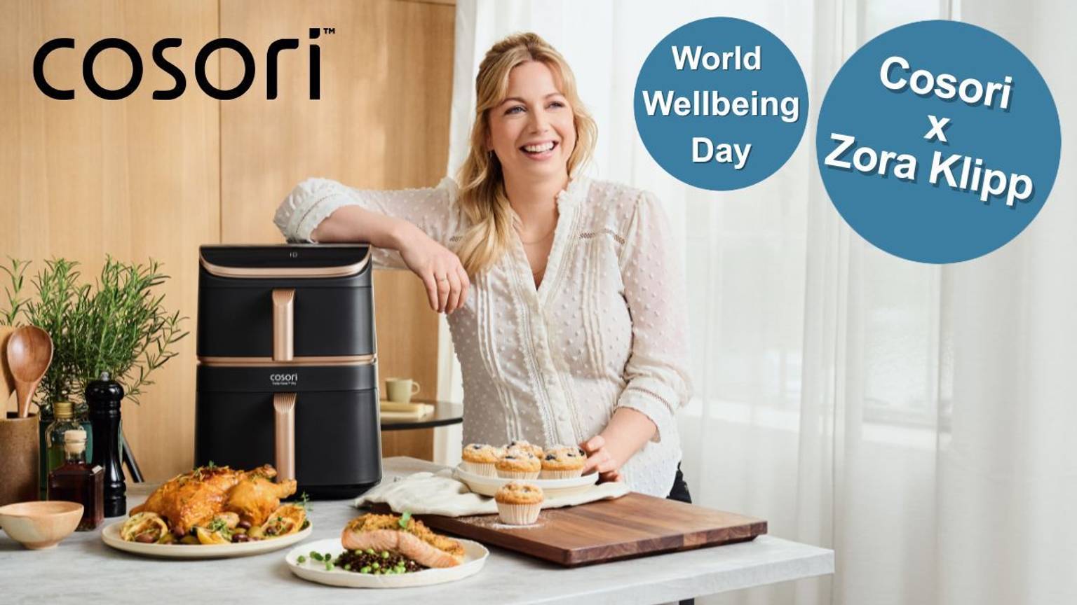 Zora Klipp lächelt neben dem Cosori Airfryer, umgeben von gesunden Gerichten aus dem Airfryer.