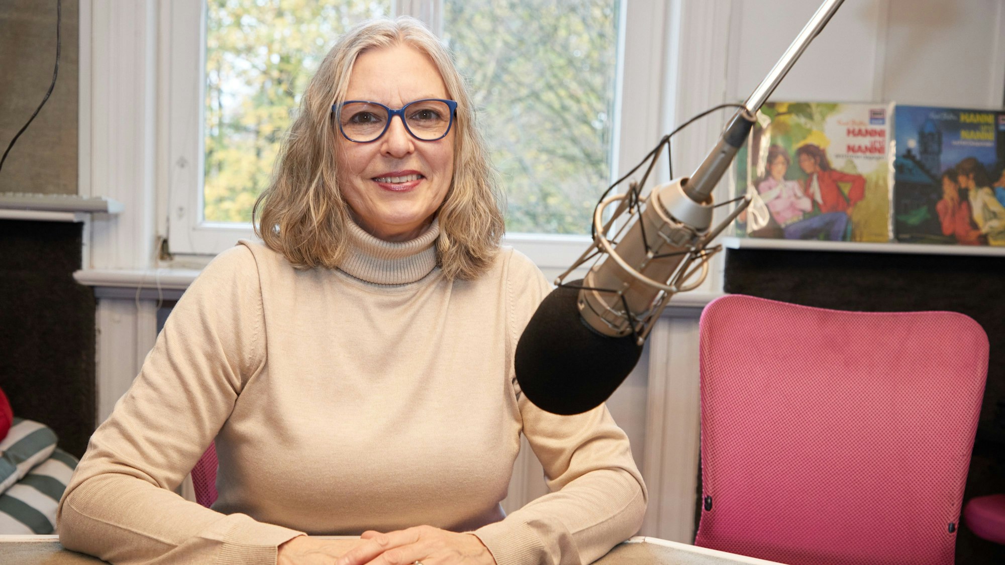 Manuela Dahm, Sprecherin, sitzt während eines Fototermins zu 50 Jahre "Hanni und Nanni"-Hörspiele vor einem Mikrofon im Tonstudio am Rothenbaum.