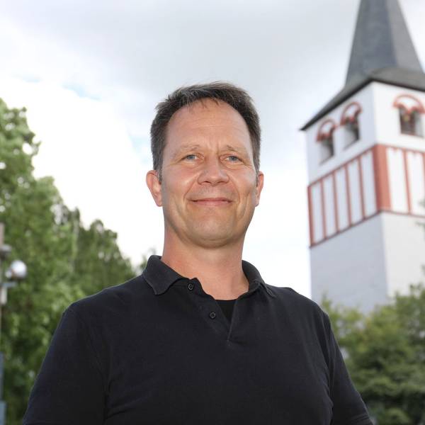Ein Mann, im Hintergrund ein Kirchturm.