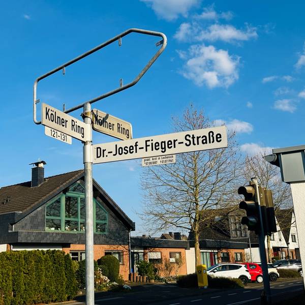 Zu sehen ist ein Straßenschild vor blauem Himmel.