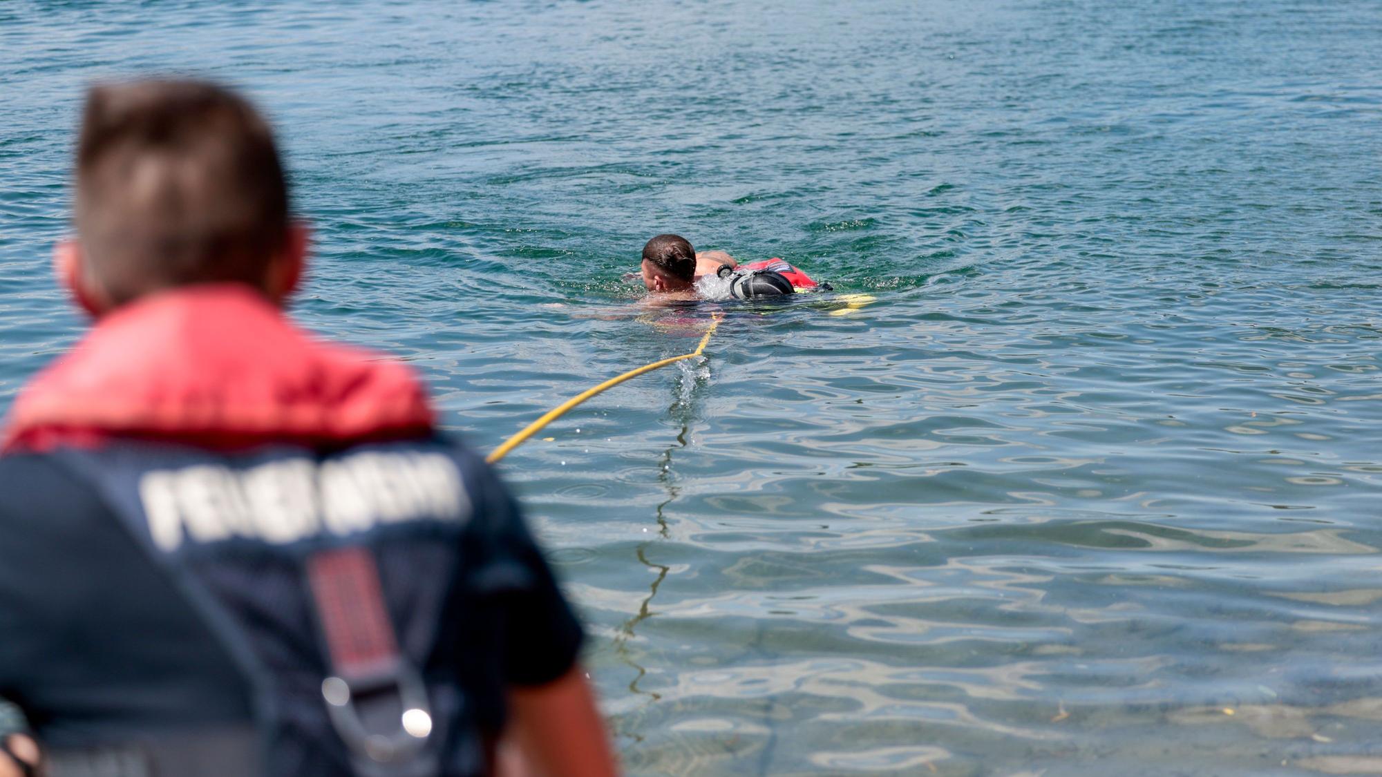 Taucher der Wasserrettung zeigen, wie sie eine Person aus dem Fühlinger See retten.