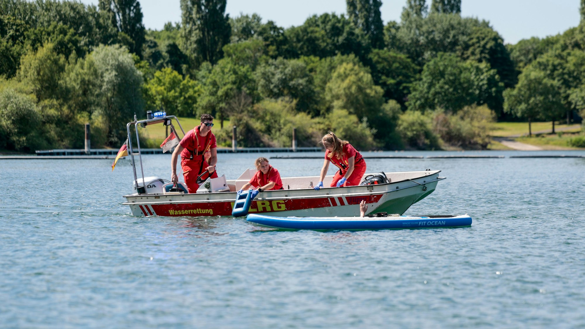 Einsatzkräfte der DLRG simulieren die Rettung einer Person aus dem Fühlinger See.