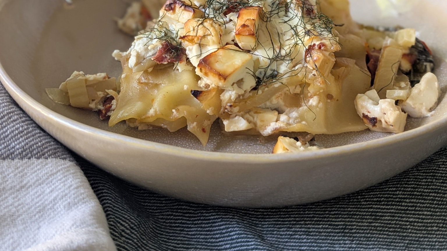 Es muss nicht immer italienisch sein: Die Lasagne bekommt durch Fetawürfel und Schafskäsegewürz einen griechischen Dreh.