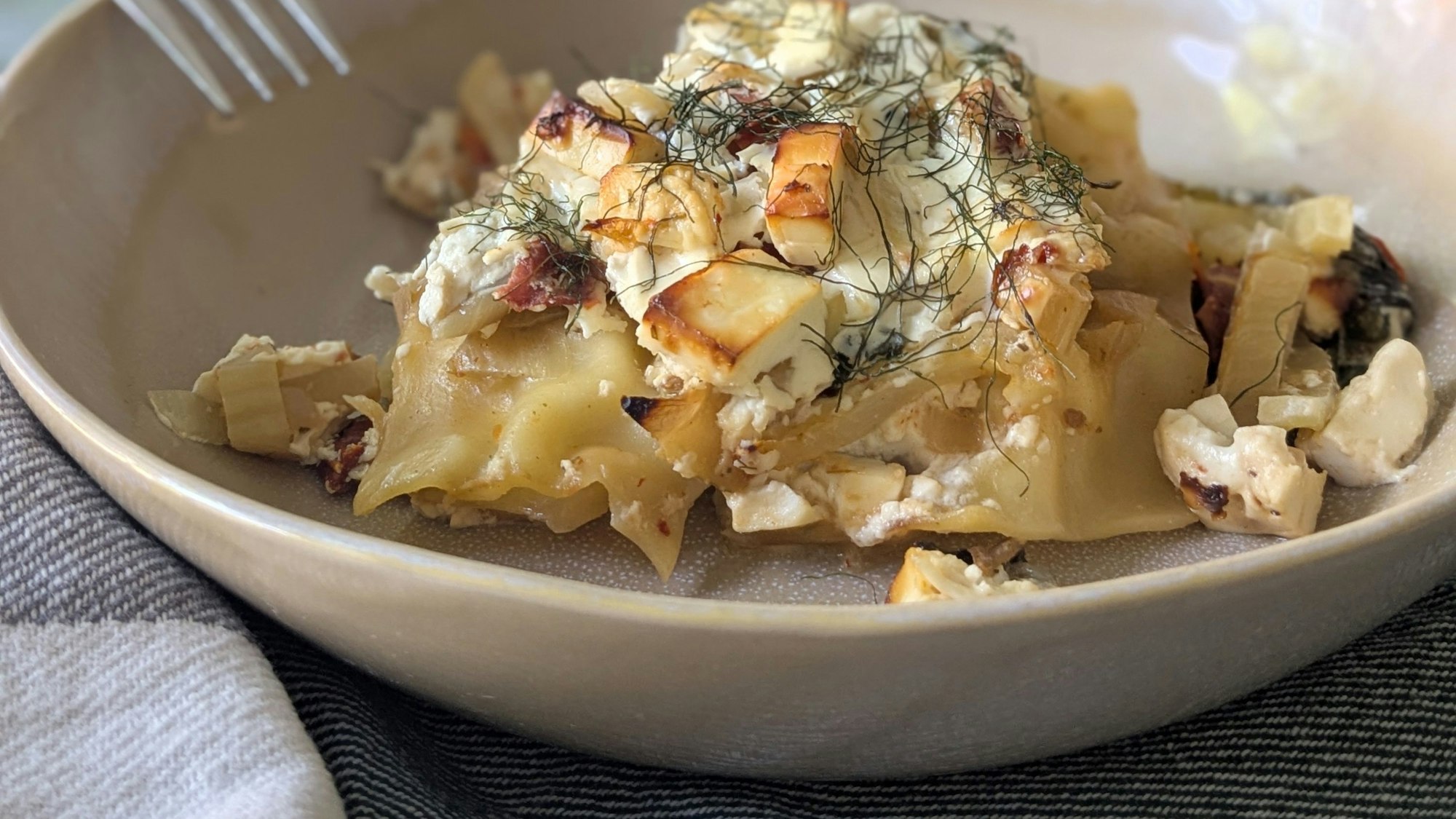 Es muss nicht immer italienisch sein: Die Lasagne bekommt durch Fetawürfel und Schafskäsegewürz einen griechischen Dreh.