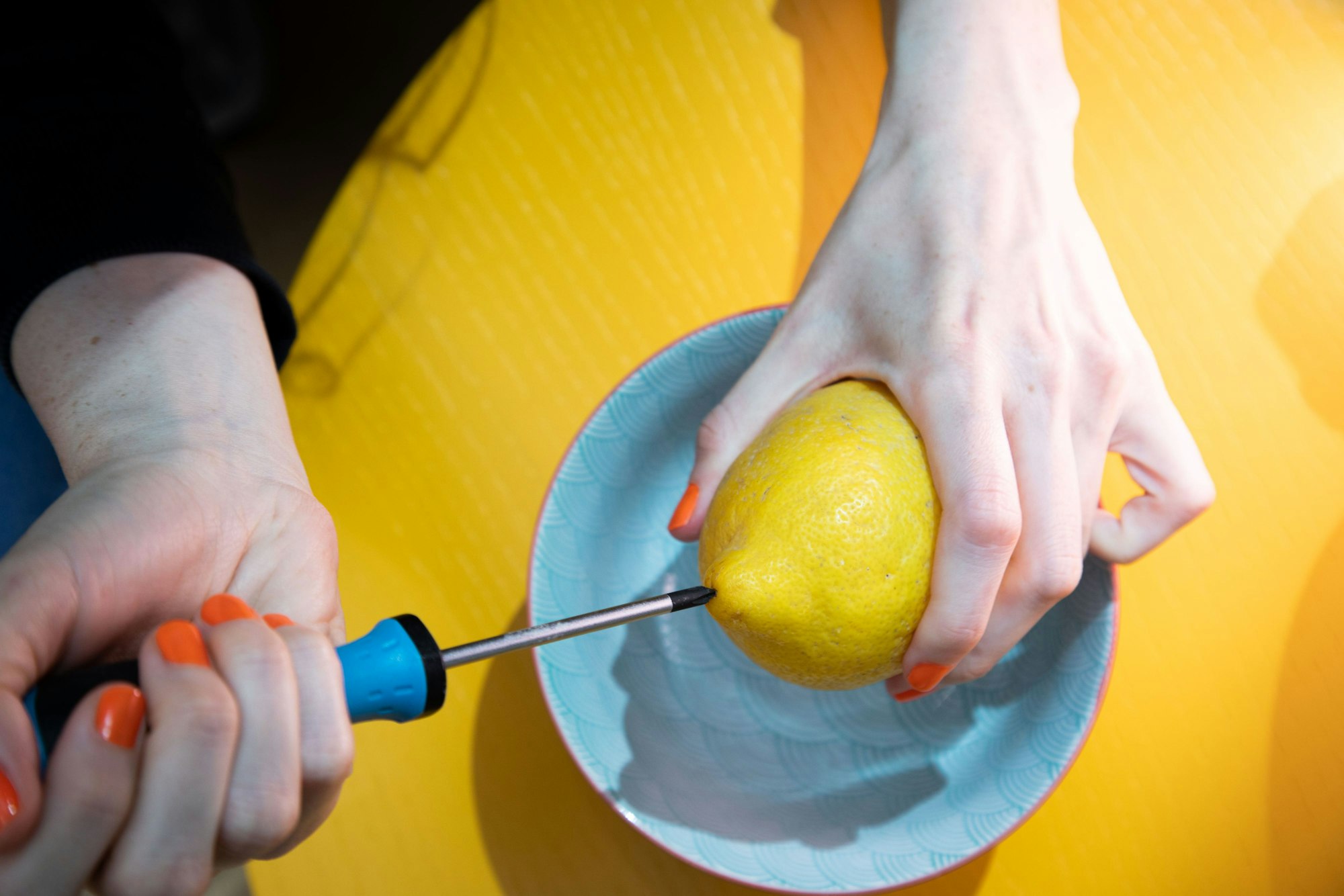 Schritt 1: Mit einem Schraubendreher in die Zitrone stechen und sie damit durchbohren.