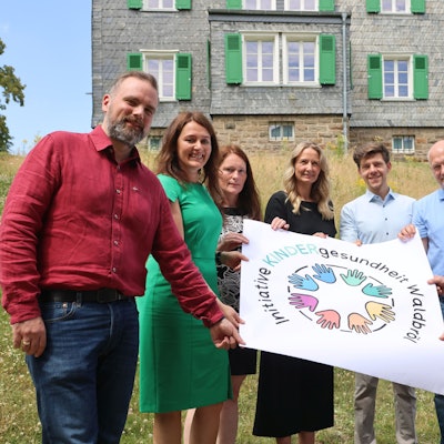 Die Akteure halten ein Plakat mit dem Logo der Initiative.