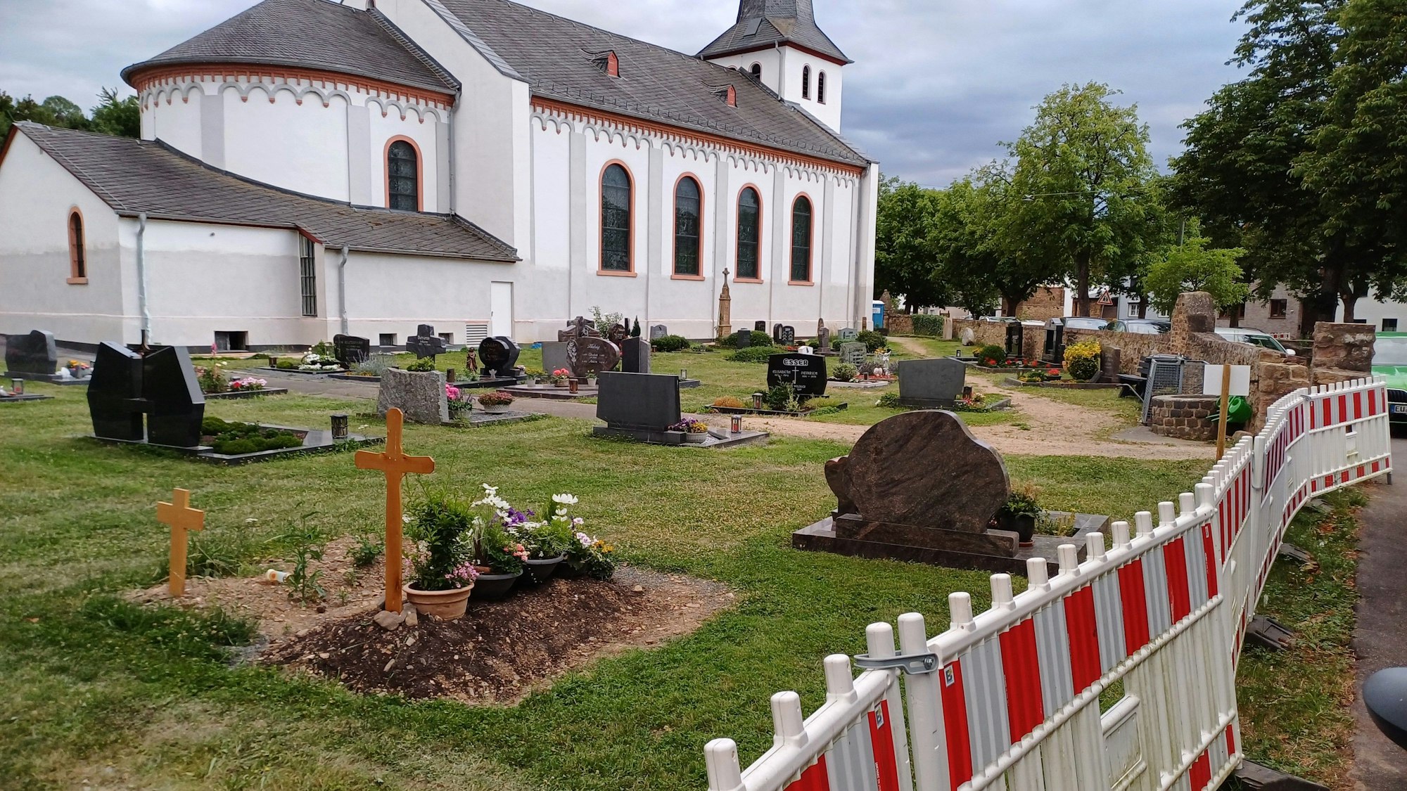 Das Bild zeigt den Friedhof mit der Kirche im Hintergrund.