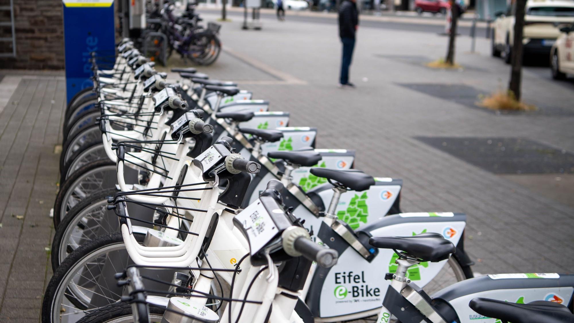 Leih-E-Bikes stehen in Reihe an einer Radstation.