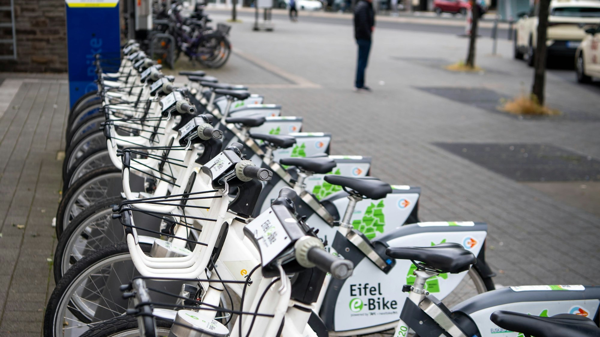 Leih-E-Bikes stehen in Reihe an einer Radstation.