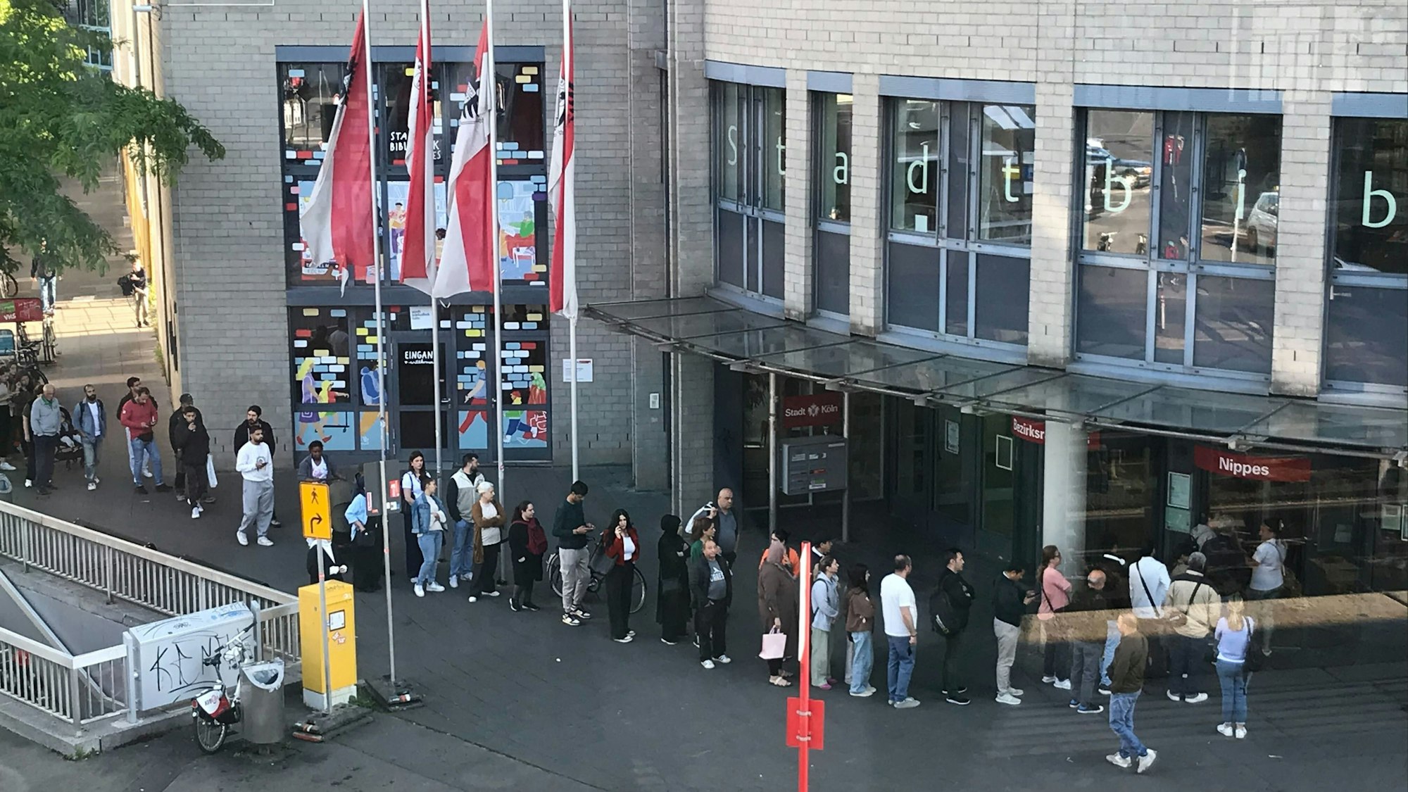 Dienstagmorgens stehen regelmäßig Migranten vor dem Bezirksamt Köln-Nippes, um ihre verlängerte Aufenthaltserlaubnis (eAT) abzuholen. Oftmals jedoch vergeblich.