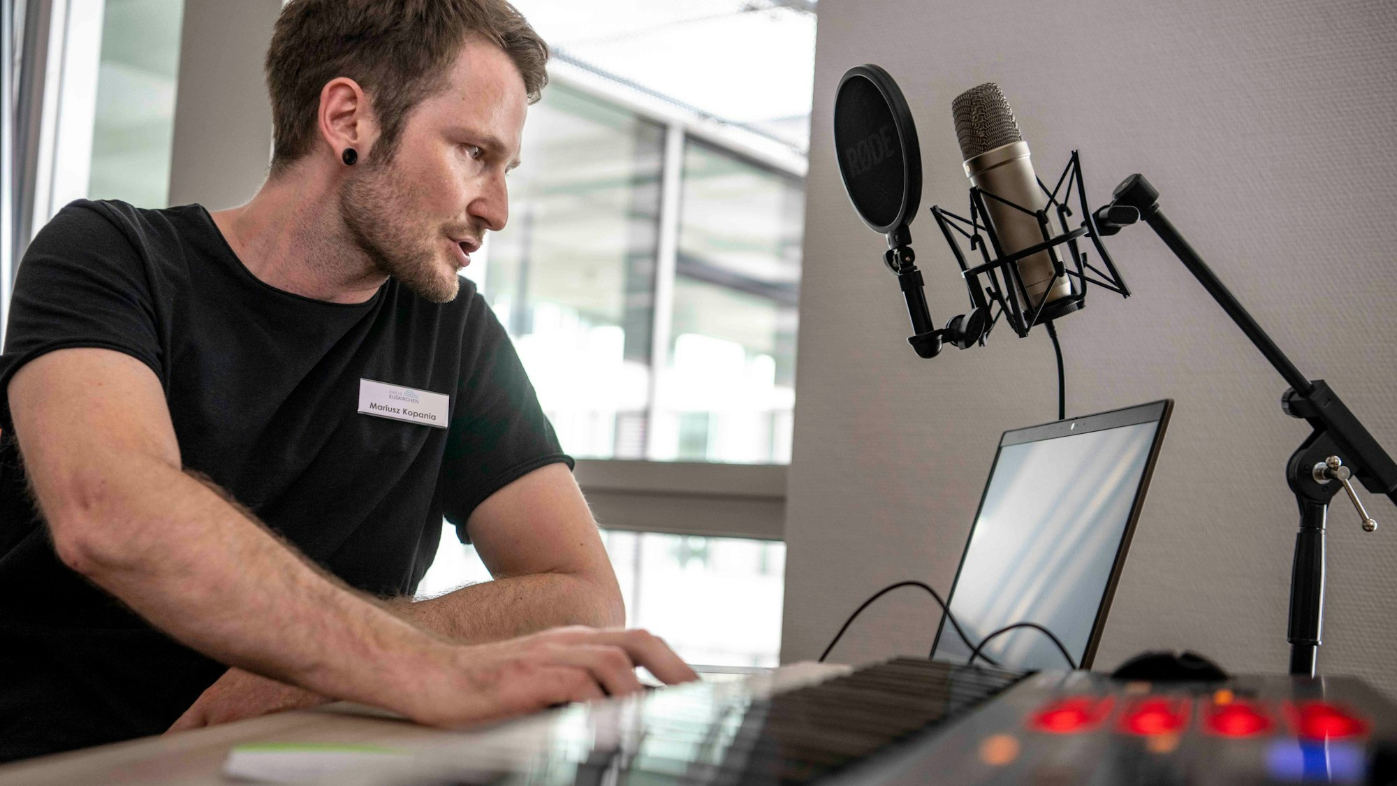 Das Bild zeigt Medienpädagoge Maruisz Kopania, der an einem Keyboard sitzt.