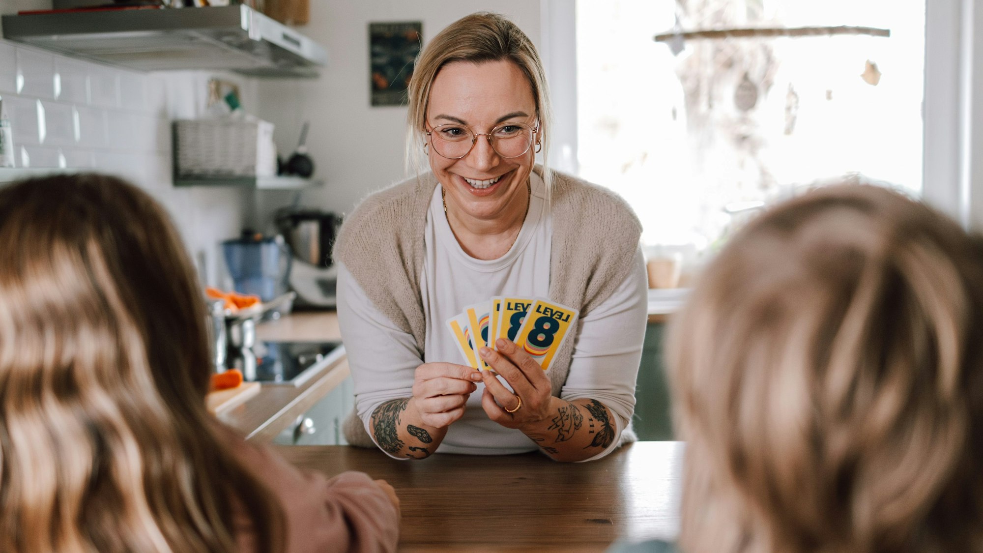 Zu sehen ist Raphaela Uhorczuk aus Bedburg, die als Mütterpflegerin tätig ist, hier im Kartenspiel mit Kindern.